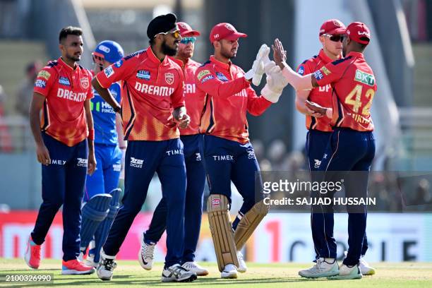 Punjab Kings' cricketers celebrate after the dismissal of Delhi Capitals' David Warner during the Indian Premier League Twenty20 cricket match...