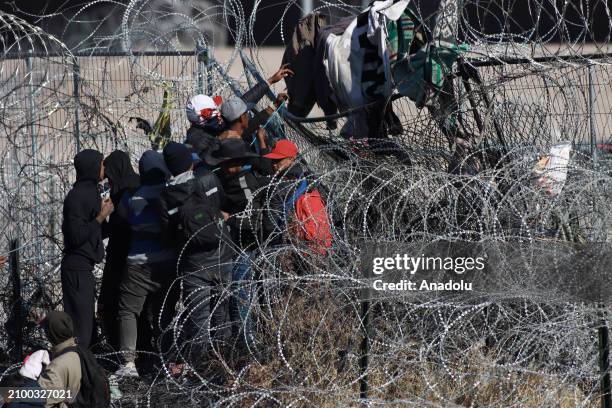 Irregular migrants try to cut with knives the razor wire fences put up by the Texas National Guard to make it more difficult for them to cross...