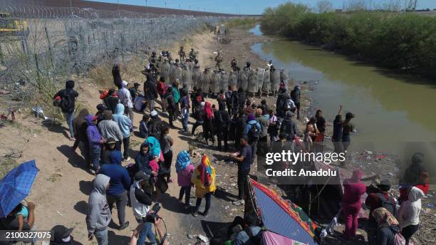 American authorities shoot rubber bullets at migrants after irregular migrants try to cut with knives the razor wire fences put up by the Texas...