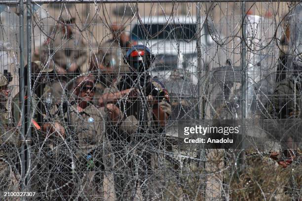 American authorities shoot rubber bullets at migrants after irregular migrants try to cut with knives the razor wire fences put up by the Texas...