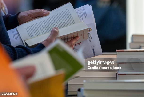 March 2024, Saxony, Leipzig: Visitors to the Leipzig Book Fair read at the Random House stand. Over 2000 exhibitors from 40 countries present their...