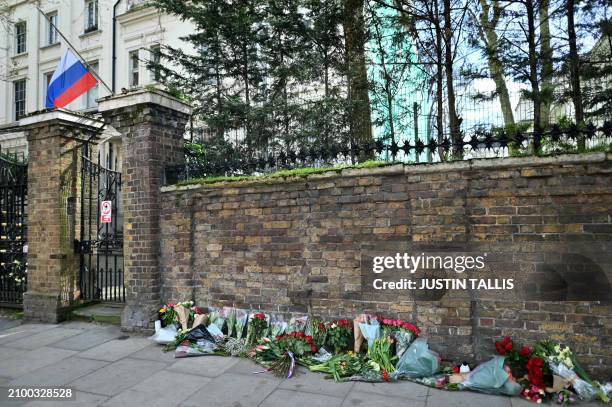 Flowers are pictured outside the Russian embassy in London on March 23 a day after a gun attack in Krasnogorsk, outside Moscow. Camouflaged...
