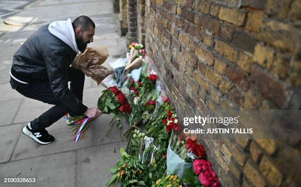 Person lays flowers outside the Russian embassy in London on March 23 a day after a gun attack in Krasnogorsk, outside Moscow. Camouflaged assailants...