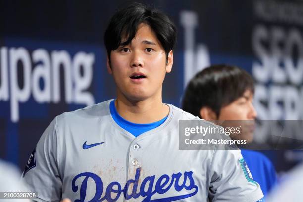 Shohei Ohtani of the Los Angeles Dodgers is seen while his interpreter Ippei Mizuhara is seen in the dugout during the 2024 Seoul Series game between...
