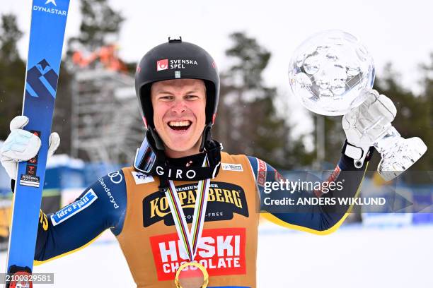 Sweden's David Mobaerg poses with the Crystal Globe of the season's overall ski cross competition after also winning the men's big final of the FIS...