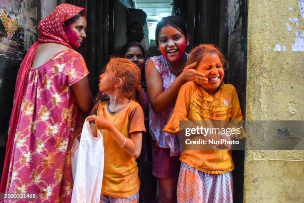 Children are smearing each other with color during the Holi festival celebration in Kolkata, India, on March 23, 2024. People are covered in color as...