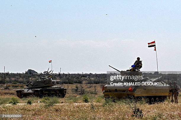 An Egyptian army M60 main battle tank and an infantry fighting vehicle are deployed near the Egyptian side of the Rafah border crossing with the Gaza...