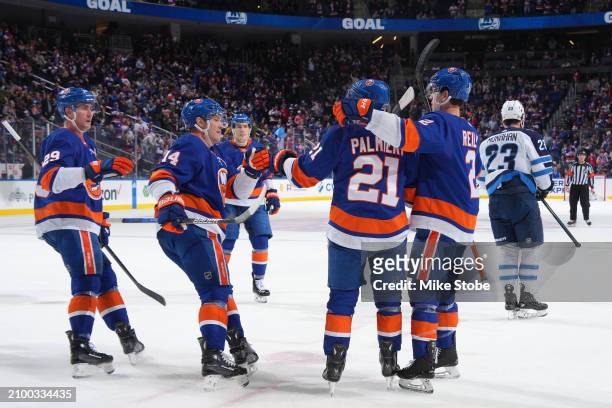 Kyle Palmieri of the New York Islanders is congratulated by his teammates after scoring a goal against the Winnipeg Jets during the first period at...