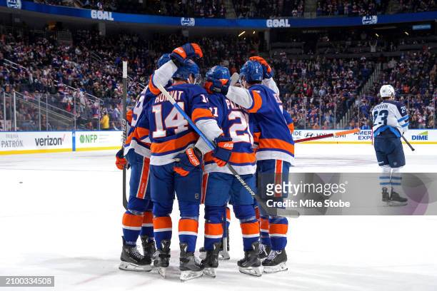 Kyle Palmieri of the New York Islanders is congratulated by his teammates after scoring a goal against the Winnipeg Jets during the first period at...