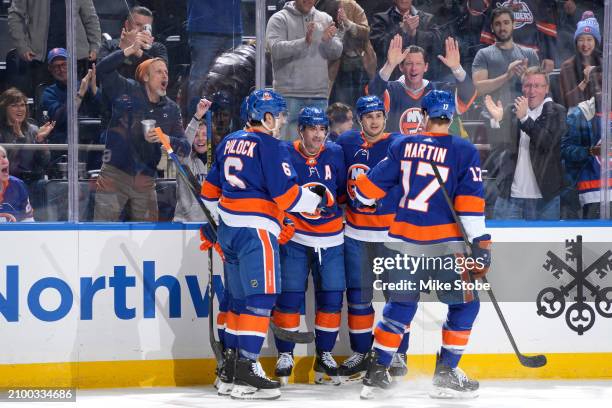 Cal Clutterbuck of the New York Islanders is congratulated by his teammates after scoring his second goal of the first period against the Winnipeg...