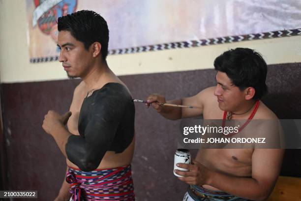 Indigenous men prepare to play a Mayan ball game match in Tecpan, Guatemala on March 23, 2024. Dressed in shorts, girdle and uncovered torso, members...