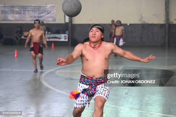 An indigenous man kicks the ball during a Mayan ball game match in Tecpan, Guatemala on March 23, 2024. Dressed in shorts, girdle and uncovered...