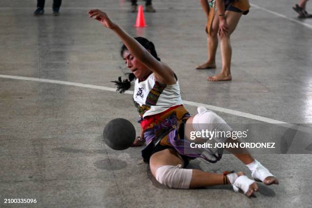 An indigenous woman kicks the ball during a Mayan ball game match in Tecpan, Guatemala on March 23, 2024. Dressed in shorts, girdle and uncovered...