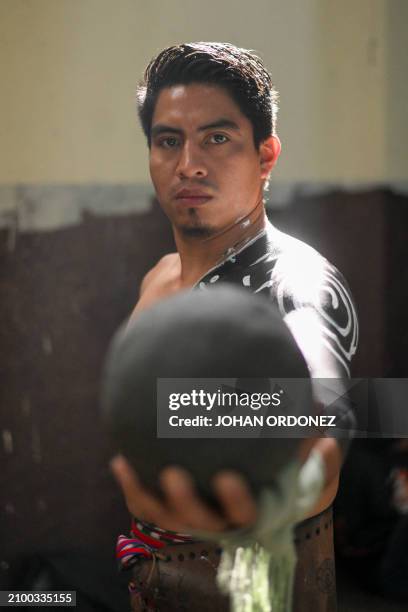 An Indigenous man poses for a picture before playing a Mayan ball game match in Tecpan, Guatemala on March 23, 2024. Dressed in shorts, girdle and...