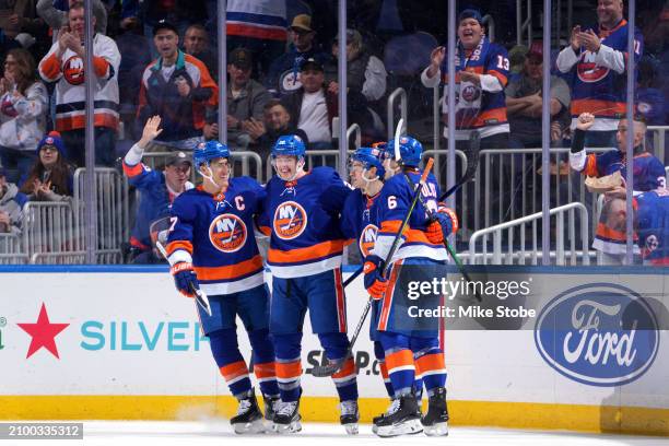 Hudson Fasching of the New York Islanders is congratulated by his teammates after scoring a goal against the Winnipeg Jets during the second period...