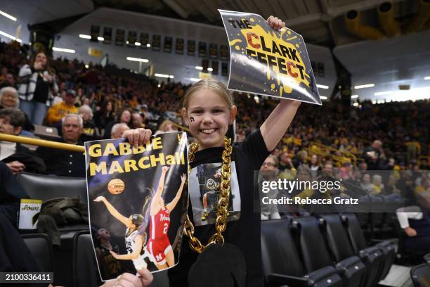 Teagan Vanhooreweghe of Waterloo, Iowa, holds signs in support of the Iowa Hawkeyes prior to tipoff against the Holy Cross Crusaders during the first...