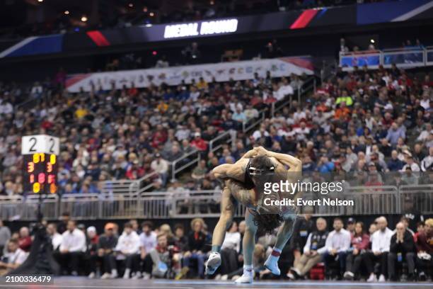 Anthony Echemendia of the Iowa State University Cyclones looks to flip Real Woods of the University of Iowa Hawkeyes in the 141-pound class during...