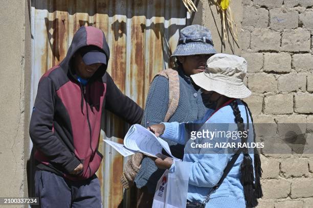 Volunteer census taker asks question to a man in Laja, Bolivia on March 23, 2024.