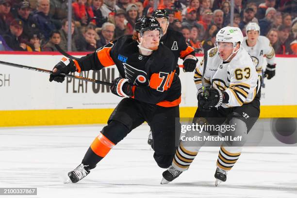 Owen Tippett of the Philadelphia Flyers skates against Brad Marchand of the Boston Bruins in the third period at the Wells Fargo Center on March 23,...