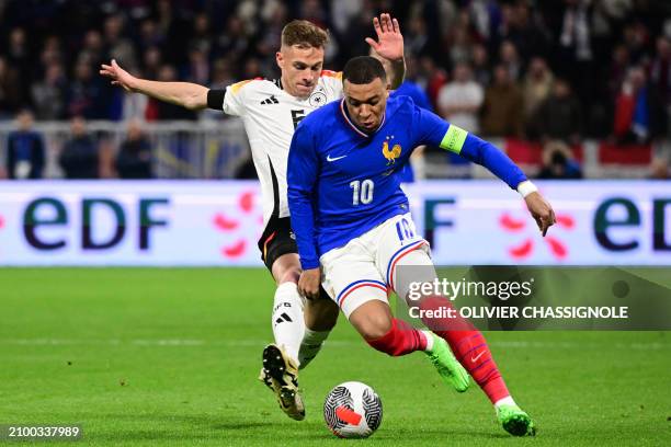 France's forward Kylian Mbappe fights for the ball with Germany's midfielder Joshua Kimmich during the friendly football match between France and...