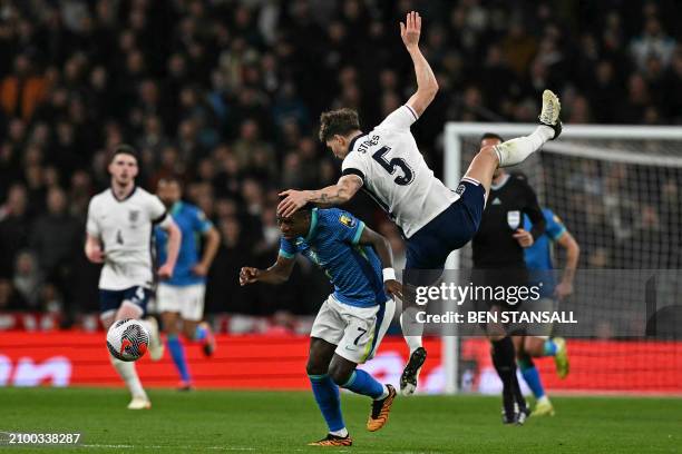 England's defender John Stones pulls back Brazil's midfielder Vinicius Jr as he threatens to break away during the international friendly football...