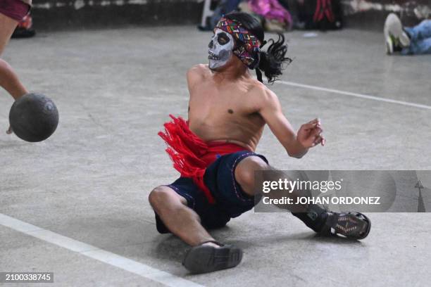 An indigenous man kicks the ball during a Mayan ball game match in Tecpan, Guatemala on March 23, 2024. Dressed in shorts, girdle and uncovered...