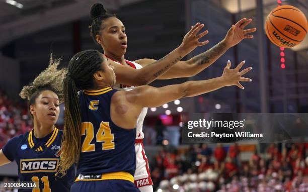 Zoe Brooks of the North Carolina State Wolfpack, top, passes against Jada Guinn and Caia Elisaldez of the Chattanooga Lady Mocs during the first...