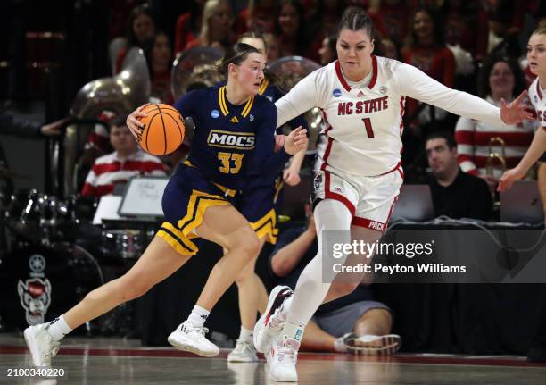 Karsen Murphy of the Chattanooga Lady Mocs drives against River Baldwin of the North Carolina State Wolfpack during the first round of the 2024 NCAA...