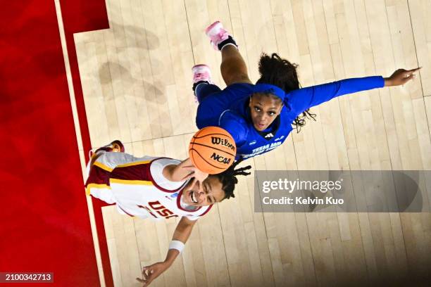 McKenzie Forbes of the USC Trojans and Nabaweeyah McGill of the Texas A&M Corpus Christi Islanders battle for the rebound during the first round of...