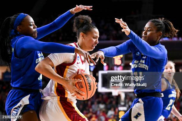 Kaitlyn Davis of the USC Trojans moves the ball while Alecia Westbrook of the Texas A&M Corpus Christi Islanders and Paige Allen of the Texas A&M...