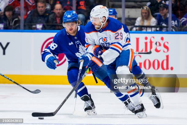 Leon Draisaitl of the Edmonton Oilers plays the puck against William Nylander of the Toronto Maple Leafs during the first period at Scotiabank Arena...