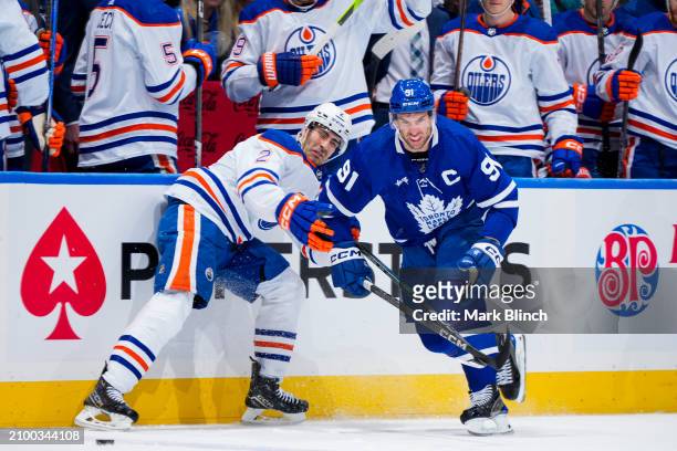 John Tavares of the Toronto Maple Leafs battles against Evan Bouchard of the Edmonton Oilers during the first period at Scotiabank Arena on March 23,...