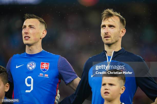 Robert Bozenik and Norbert Gyoember of Slovakia stand for the national anthem prior to the international friendly match between Slovakia and Austria...