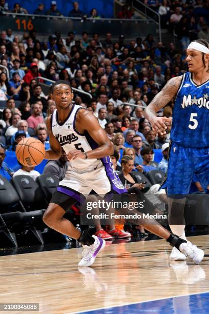 De'Aaron Fox of the Sacramento Kings handles the ball against Paolo Banchero of the Orlando Magic during the game on March 23, 2024 at the Kia Center...