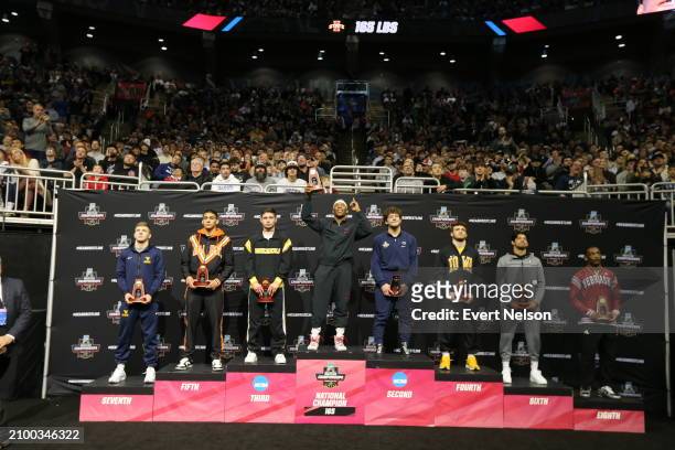 The 165-pound weight class finalists lift trophies during the Division I Men's Wrestling Championship held at T-Mobile Center on March 23, 2024 in...