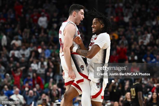 Michael O'Connell of the North Carolina State Wolfpack celebrates with Jayden Taylor following a 79-73 overtime win over the Oakland Golden Grizzlies...