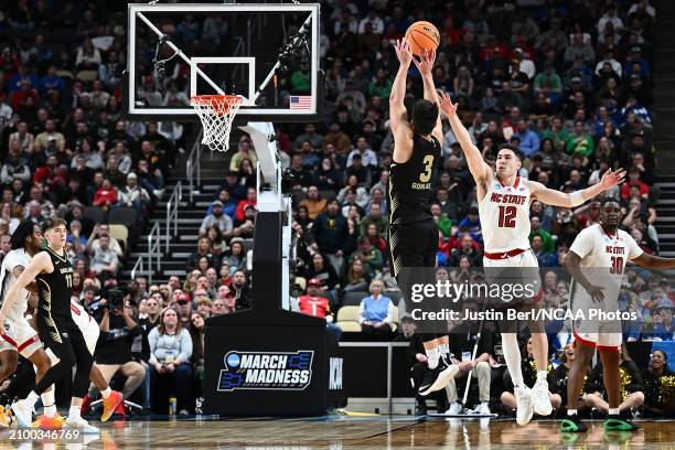 Jack Gohlke of the Oakland Golden Grizzlies attempts a three point shot over Michael O'Connell of the North Carolina State Wolfpack in overtime...