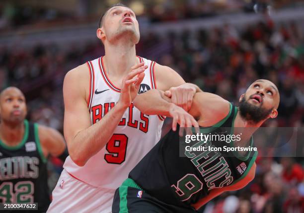 Nikola Vucevic of the Chicago Bulls box out Derrick White of the Boston Celtics during the second half at the United Center on March 23, 2024 in...