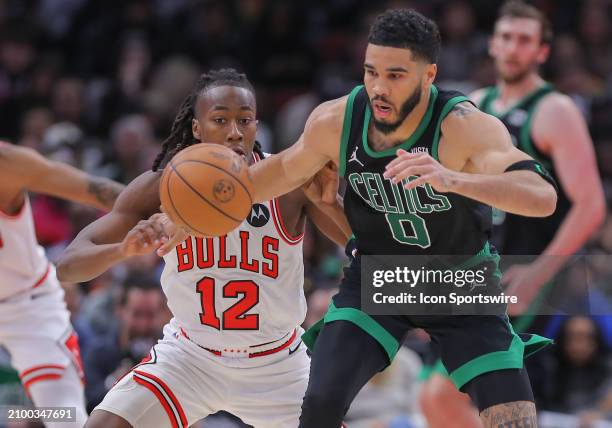 Ayo Dosunmu of the Chicago Bulls pushes the ball away from Jayson Tatum of the Boston Celtics during the second half at the United Center on March...