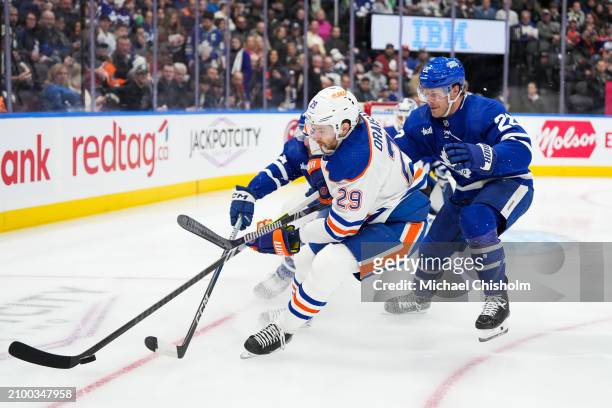 Leon Draisaitl of the Edmonton Oilers plays the puck against Jake McCabe of the Toronto Maple Leafs at Scotiabank Arena on March 23, 2024 in Toronto,...