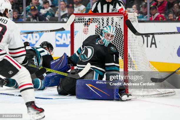 Devin Cooley of the San Jose Sharks stops the puck against the Chicago Blackhawks at SAP Center on March 23, 2024 in San Jose, California.