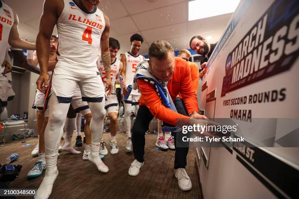 Head coach Brad Underwood of the Illinois Fighting Illini moves the team's card into the sweet sixteen spot on the bracket after defeating the...