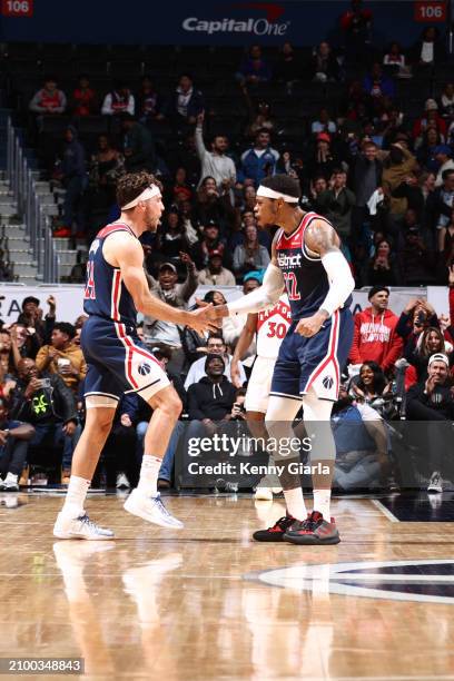 Corey Kispert of the Washington Wizards & Richaun Holmes of the Washington Wizards high five during the game on March 23, 2024 at Capital One Arena...