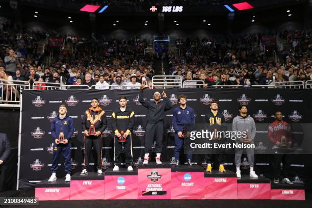The 165-pound weight class finalists lift trophies during the Division I Men's Wrestling Championship held at T-Mobile Center on March 23, 2024 in...