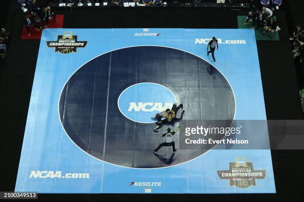 Caleb Henson of the Virginia Tech Hokies competes against Austin Gomez of the University of Michigan Wolverines in the 149-pound class during the...