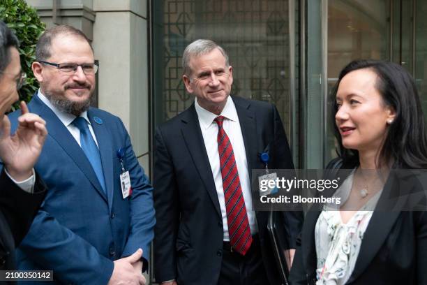 Cristiano Amon, chief executive officer of Qualcomm Inc., left, and Alex Rogers, president of Qualcomm Technology Licensing, center, leave the hotel...