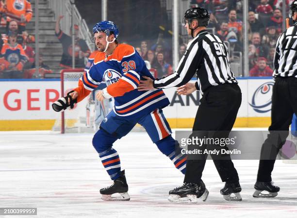 Sam Carrick of the Edmonton Oilers is guided to the the penalty box by linesman Travis Toomey during game against the Montreal Canadiens at Rogers...