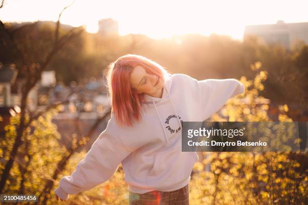 happy young woman enjoying the sun while standing in the park during spring - kyiv spring stock pictures, royalty-free photos & images