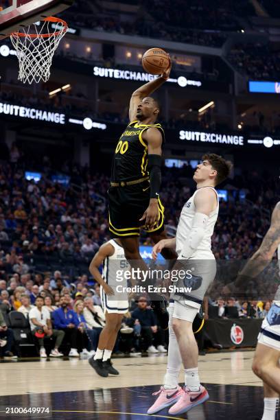 Jonathan Kuminga of the Golden State Warriors goes up for a dunk on Jake LaRavia of the Memphis Grizzlies in the first half at Chase Center on March...