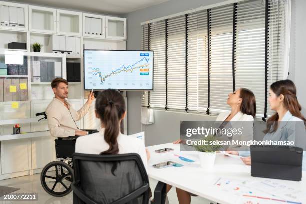 disabled business man in wheelchair giving presentation to colleagues. - inclusion body stock-fotos und bilder